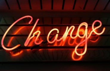 A picture of a sign lit up with the word Change